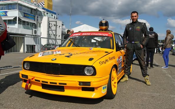Ioannis Smyrlis neben dem BMW E30 V8 der DMV BMW Challenge